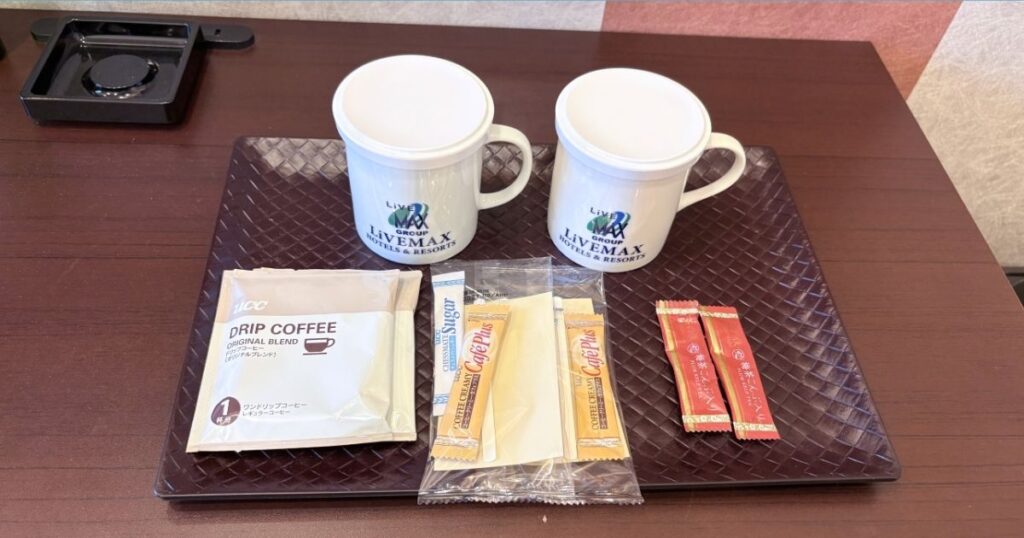 ホテルリブマックスPREMIUM名古屋丸の内のラグジュアリーシングルルームのマグカップとコーヒー、お茶