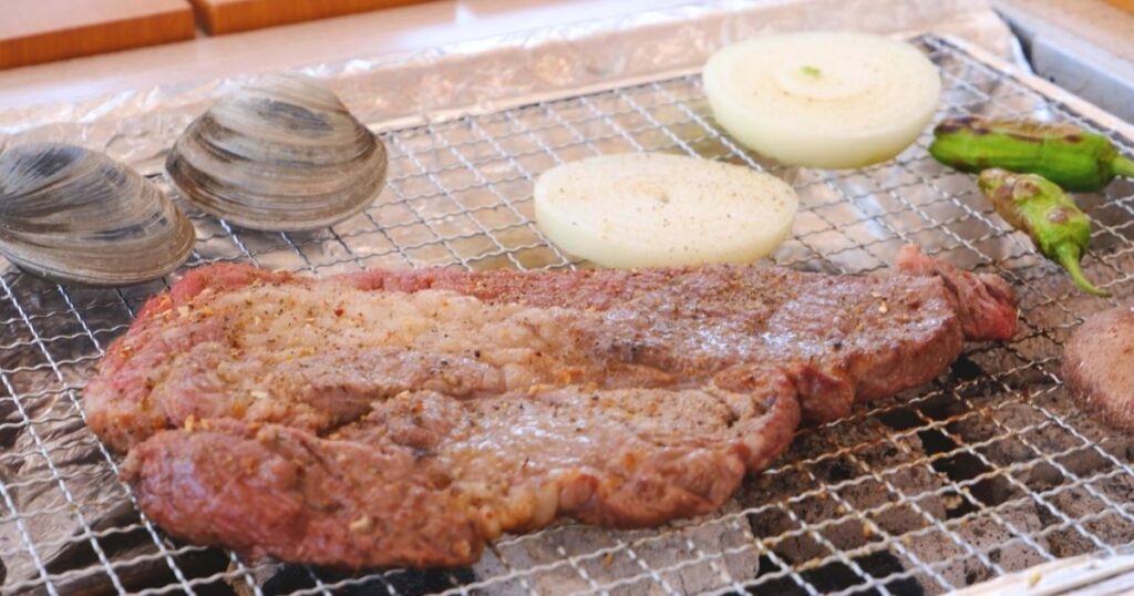 網の上で焼いているステーキ用牛肉肩ロース
