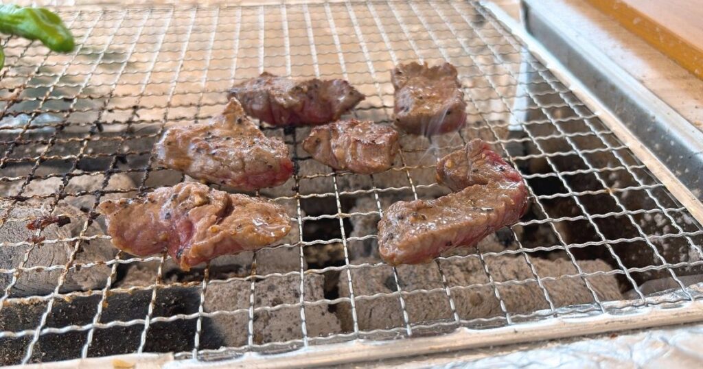 網の上で焼いている牛ガーリックステーキ